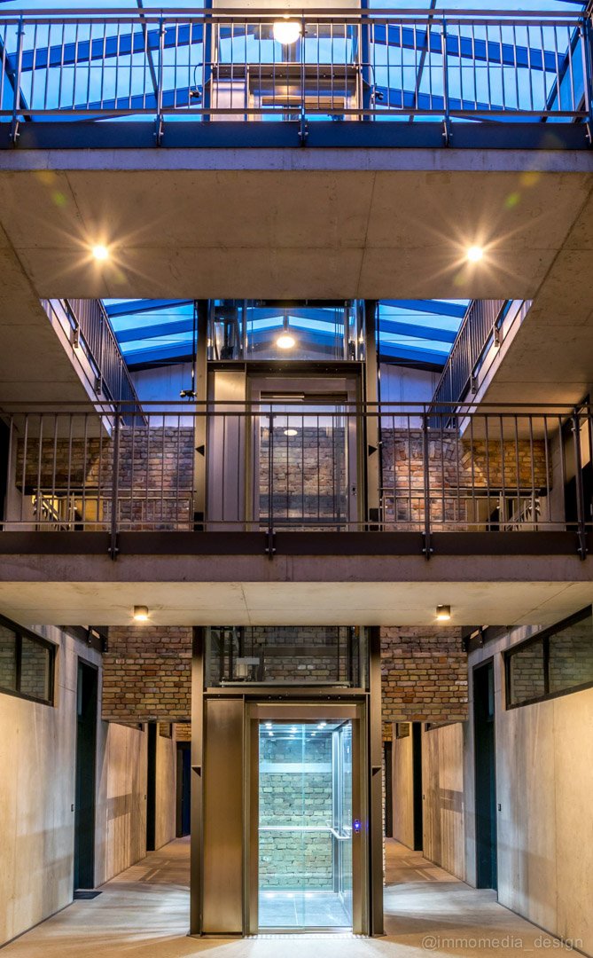 Atrium eines sanierten Loftgebäudes mit beleuchteter Lichtdecke